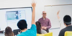 students in class raising hand