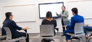 An instructor stands at the front of the class